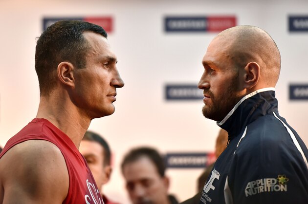 Challenger Tyson Fury watches world champion Wladimir Klitschko, left, after the Official Weigh-In in Essen, Germany, prior their heavyweight boxing fight, Friday, Nov. 27, 2015. The title clash will take place in Duesseldorf's LTU arena on Saturday. (AP Photo/Martin Meissner)