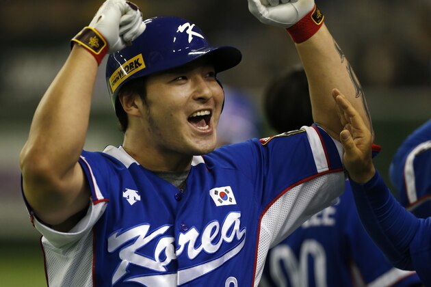 South Korea's Park Byung-ho celebrates at the bench after hitting a three-run home run against Team USA in the fourth inning of their final game at the Premier12 world baseball tournament at Tokyo Dome in Tokyo, Saturday, Nov. 21, 2015. (AP Photo/Toru Takahashi)