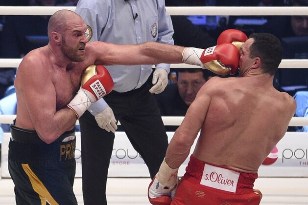 Britain's Tyson Fury, left, punches Ukraine's Wladimir Klitschko and in a world heavyweight title fight for Klitschko's WBA, IBF, WBO and  IBO belts in the Esprit Arena in Duesseldorf, western Germany, Saturday, Nov. 28, 2015. (AP Photo/Sebastian Konopka)