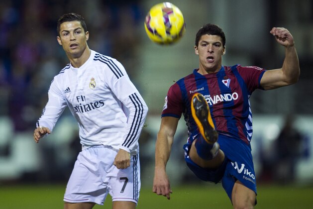 EIBAR, SPAIN - NOVEMBER 22: Cristiano Ronaldo of Real Madrid duels for the ball with Ander Capa  of SD Eibar during the La Liga match between SD Eibar and Real Madrid at Ipurua Municipal Stadium on November 22, 2014 in Eibar, Spain.  (Photo by Juan Manuel Serrano Arce/Getty Images)