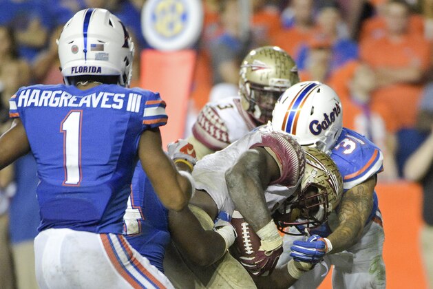 Florida State running back Dalvin Cook, center pushes past Florida defensive back Vernon Hargreaves III (1) and defensive back Jalen Tabor (31) for a touchdown during the second half of an NCAA college football game, Saturday, Nov. 28, 2015, in Gainesville, Fla. (AP Photo/Phelan M. Ebenhack)