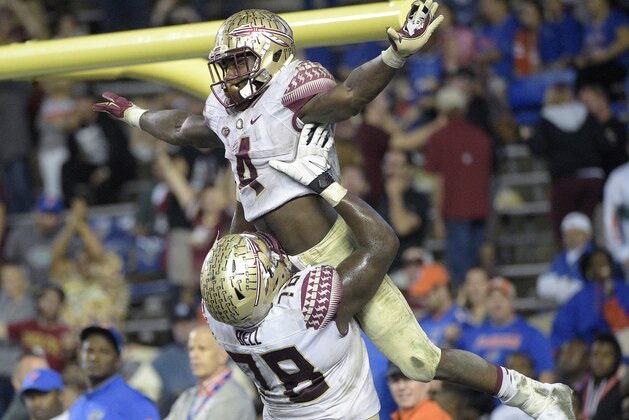 Florida State running back Dalvin Cook (4) is congratulated by offensive lineman Wilson Bell (78) after rushing for a 29-yard touchdown during the second half of an NCAA college football game against Florida in Gainesville, Fla., Saturday, Nov. 28, 2015. Florida State won 27-2. (AP Photo/Phelan M. Ebenhack)