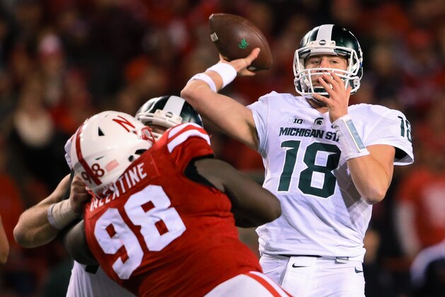 FILE - In this Nov. 7, 2015, file photo, Michigan State quarterback Connor Cook (18) throws during the team's NCAA college football game against Nebraska in Lincoln, Neb. Cook missed much of last week's game after taking a shot to his throwing shoulder. He says he is fine for this week's game against Ohio State. (AP Photo/Nati Harnik, File)