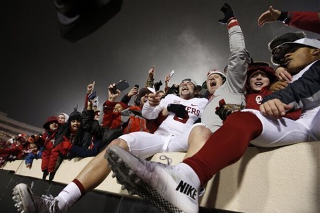Oklahoma quarterback Baker Mayfield, center, celebrates with fans following an NCAA college football game against Oklahoma State in Stillwater, Okla., Saturday, Nov. 28, 2015. Oklahoma won 58-23. (AP Photo/Sue Ogrocki)
