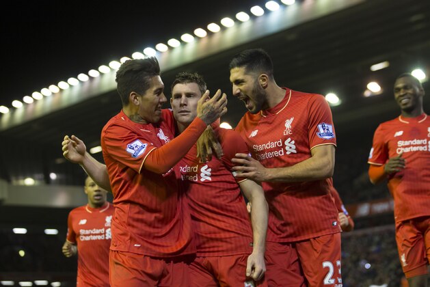 Liverpool's James Milner, centre, celebrates with teammates after scoring a penalty during the English Premier League soccer match between Liverpool and Swansea at Anfield Stadium, Liverpool, England, Sunday, Nov. 29, 2015. (AP Photo/Jon Super)