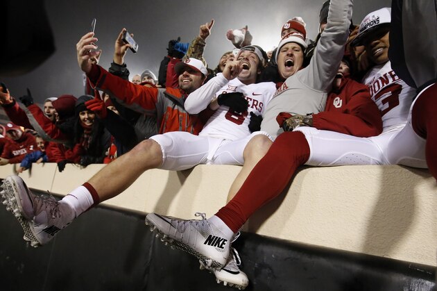 Oklahoma quarterback Baker Mayfield, center, celebrates with fans following an NCAA college football game against Oklahoma State in Stillwater, Okla., Saturday, Nov. 28, 2015. Oklahoma won 58-23. (AP Photo/Sue Ogrocki)