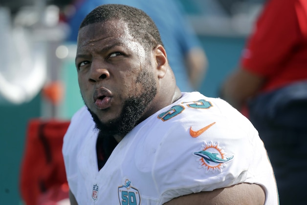 Miami Dolphins defensive tackle Ndamukong Suh (93) looks up from the sidelines during the first half of an NFL football game against the Dallas Cowboys, Sunday, Nov. 22, 2015, in Miami Gardens, Fla.  (AP Photo/Wilfredo Lee)