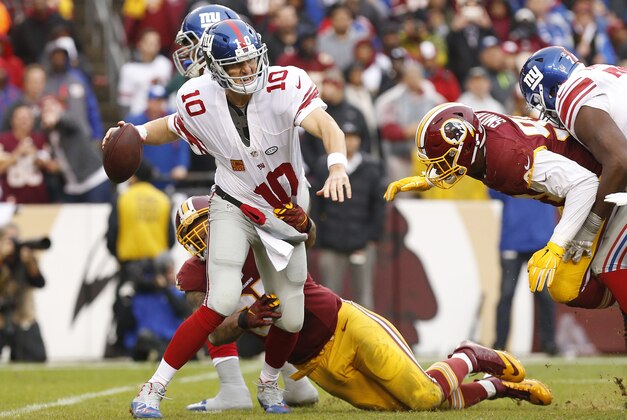 Nov 29, 2015; Landover, MD, USA; New York Giants quarterback Eli Manning (10) attempts to throw the ball while being sacked by Washington Redskins defensive end Jason Hatcher (97) in the third quarter at FedEx Field. The Redskins won 20-14. Mandatory Credit: Geoff Burke-USA TODAY Sports
