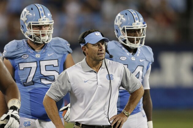 FILE - In this Sept. 3, 2015, file photo, North Carolina head coach Larry Fedora talks to his team during a timeout in the second half of an NCAA college football game against South Carolina in Charlotte, N.C. North Carolina’s offense is rolling to big yardage totals and Atlantic Coast Conference-record scoring outputs. But there’s another telling stat in the No. 12 Tar Heels’ rise to their highest ranking in 17 years: three straight games with a “zero” in the turnover column.  (AP Photo/Chuck Burton, File)