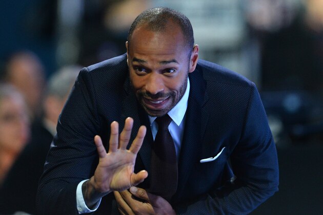 Former French international Thierry Henry waves during a men's singles semi-final match between Switzerland's Roger Federer and Switzerland's Stan Wawrinka on day seven of the ATP World Tour Finals tennis tournament in London on November 21, 2015. 
AFP PHOTO / GLYN KIRK        (Photo credit should read GLYN KIRK/AFP/Getty Images)