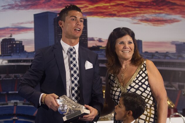 Real Madrid’s striker Cristiano Ronaldo, left, poses with his mother Dolores and his son Cristiano Ronaldo Junior after receiving a silver boot award for scoring the most goals for the club during a ceremony at the Santiago Bernabeu stadium in Madrid, Spain, Friday Oct. 2, 2015. Real Madrid paid tribute to Ronaldo, who recently overtook Raul Gonzalez to become the club's all-time highest goalscorer. (AP Photo/Paul White)