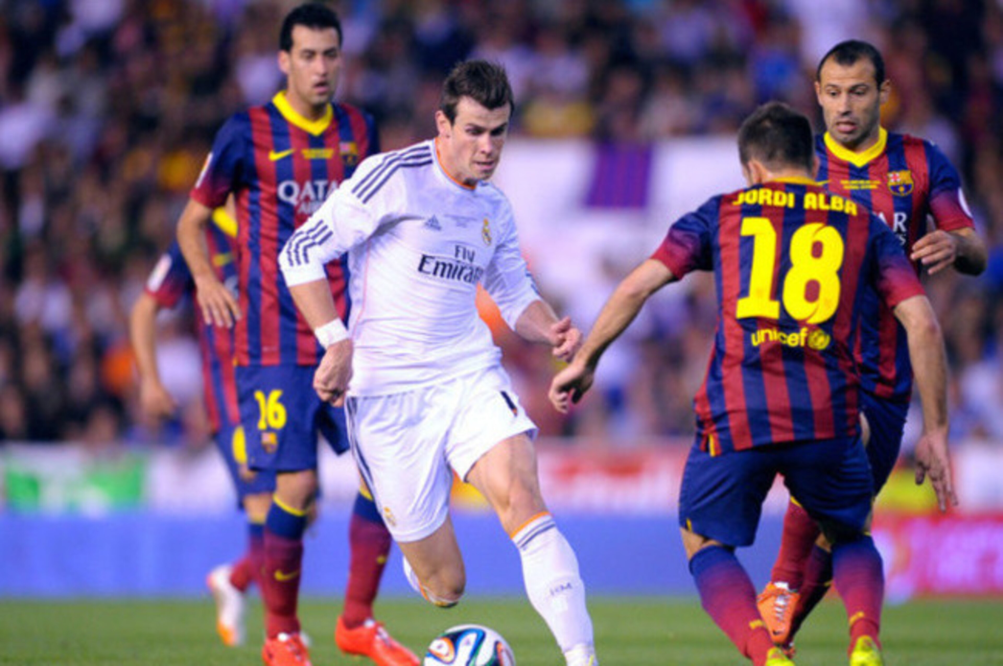 Real's Gareth Bale, center, drives the ball past Barcelona's Jordi Alba during the final of the Copa del Rey between FC Barcelona and Real Madrid at the Mestalla stadium in Valencia, Spain, Wednesday, April 16, 2014. (AP Photo/Manu Fernandez)