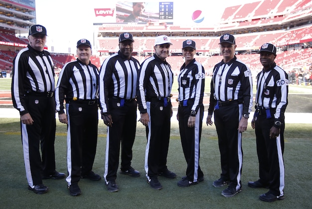 Head linesman Ed Camp, from left, field judge Jeff Lamberth, umpire Ruben Fowler, referee Peter Morelli, line judge Sarah Thomas, side judge Rob Vernatchi and back judge Dale Shaw pose for photos before an NFL football game between the San Francisco 49ers and the Arizona Cardinals in Santa Clara, Calif., Sunday, Nov. 29, 2015. (AP Photo/Tony Avelar)