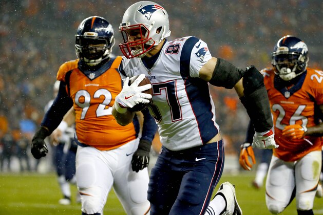 New England Patriots tight end Rob Gronkowski (87) scores a touchdown as Denver Broncos nose tackle Sylvester Williams (92) defends during the first half of an NFL football game, Sunday, Nov. 29, 2015, in Denver. (AP Photo/Jack Dempsey)
