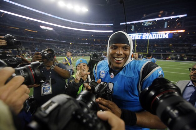 Carolina Panthers' Cam Newton smiles as the cameras after taking one into his own hands to make pictures following the Panthers NFL football game against the Dallas Cowboys, Thursday, Nov. 26, 2015, in Arlington, Texas. (AP Photo/Michael Ainsworth)