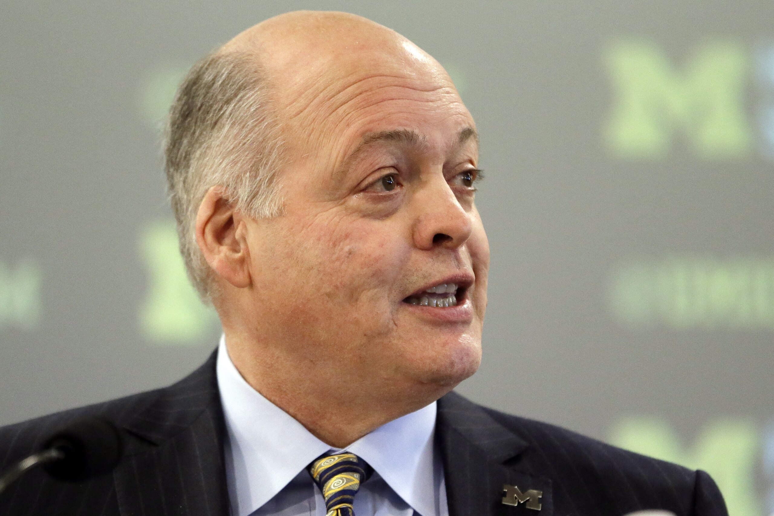 Michigan interim athletic director Jim Hackett addresses the media before introducing Jim Harbaugh as the new head coach of Michigan in Ann Arbor, Mich., Tuesday, Dec. 30, 2014. (AP Photo/Carlos Osorio)