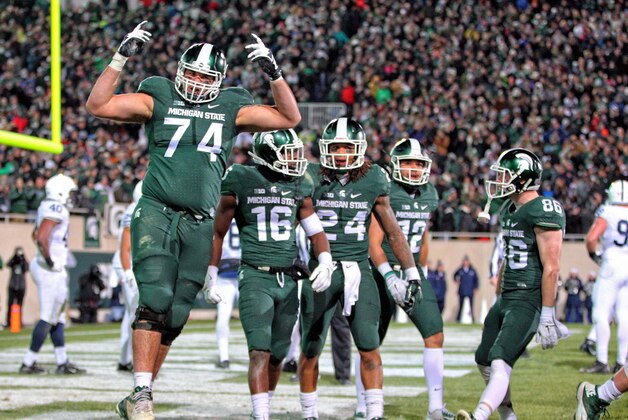 Nov 28, 2015; East Lansing, MI, USA; Michigan State Spartans offensive tackle Jack Conklin (74) and wide receiver Aaron Burbridge (16) and running back Gerald Holmes (24) celebrate a touchdown during the second half of a game at Spartan Stadium. Mandatory Credit: Mike Carter-USA TODAY Sports