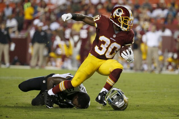 Jacksonville Jaguars cornerback Rashaad Reynolds (40) looses his helmet attempting to stop Washington Redskins running back Trey Williams (30) during the first half of an NFL preseason football game in Landover, Md., Thursday, Sept. 3, 2015. (AP Photo/Alex Brandon)