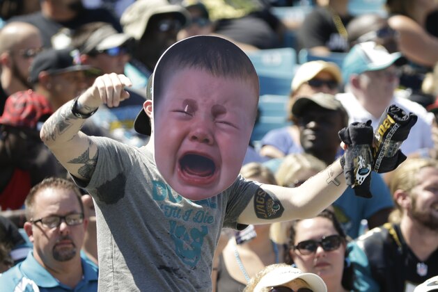 A Jacksonville Jaguars fan covers his face with a mask of a crying baby as the Indianapolis Colts take an early lead during the first half of an NFL football game in Jacksonville, Fla., Sunday, Sept. 21, 2014. (AP Photo/Stephen B. Morton)