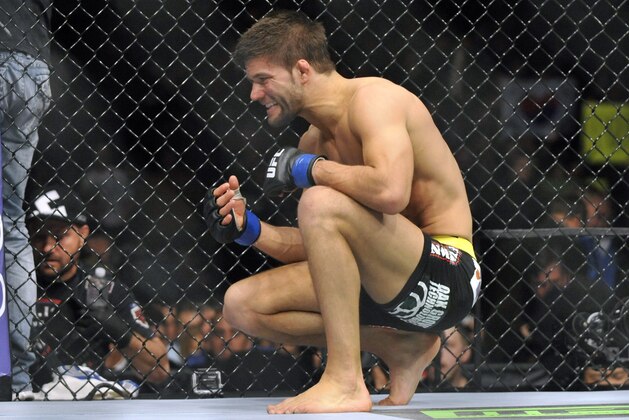 Jan 25, 2014; Chicago, IL, USA; Josh Thomson (blue gloves) reacts after losing to Benson Henderson (red gloves) during UFC on FOX 10 at the United Center. Mandatory Credit: David Banks-USA TODAY Sports