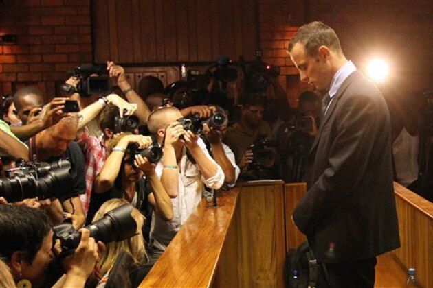 FILE - In this Friday, Feb 22, 2013 file photo photographers take photos of Olympic athlete Oscar Pistorius as he appears at a bail hearing for the shooting death of his girlfriend Reeva Steenkamp, in Pretoria, South Africa.  (AP Photo/Themba Hadebe-File)