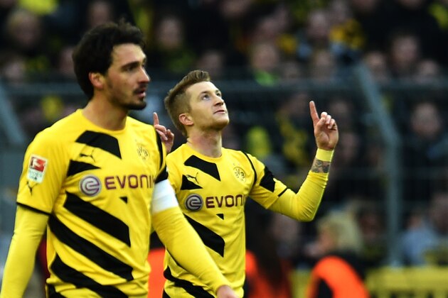 Dortmund's striker Marco Reus (R) and Dortmund's defender Mats Hummels celebrate during the German first division Bundesliga football match Borussia Dortmund vs FC Schalke 04 in Dortmund, western Germany, on February 28, 2015. Dortmund won the match 3-0.    AFP PHOTO / PATRIK STOLLARZ

DFL RULES TO LIMIT THE ONLINE USAGE DURING MATCH TIME TO 15 PICTURES PER MATCH. IMAGE SEQUENCES TO SIMULATE VIDEO IS NOT ALLOWED AT ANY TIME. FOR FURTHER QUERIES PLEASE CONTACT DFL DIRECTLY AT + 49 69 650050.        (Photo credit should read PATRIK STOLLARZ/AFP/Getty Images)
