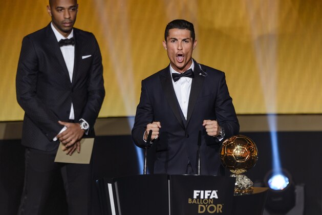 Real Madrid and Portugal forward Cristiano Ronaldo (R) reacts next to French former star player Thierry Henry (L) after receiving the 2014 FIFA Ballon d'Or award for player of the year during the FIFA Ballon d'Or award ceremony at the Kongresshaus in Zurich on January 12, 2015. AFP PHOTO / FABRICE COFFRINI        (Photo credit should read FABRICE COFFRINI/AFP/Getty Images)