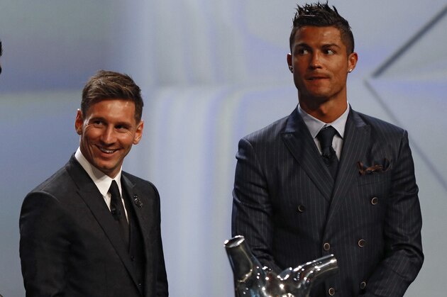 FC Barcelone Argentinian striker Lionel Messi (2ndR) shares a laugh with his Urugayan teammate Luis Suarez (2ndL) and Danish former football player and ceremony host Peter Schmeichel (L) eyed by Real Madrid's Portuguese striker Cristiano Ronaldo during the awarding ceremony for the Best Men's player in Europe at the end of the UEFA Champions League Group stage draw ceremony, on August 27, 2015 in Monaco. AFP PHOTO / VALERY HACHE        (Photo credit should read VALERY HACHE/AFP/Getty Images)