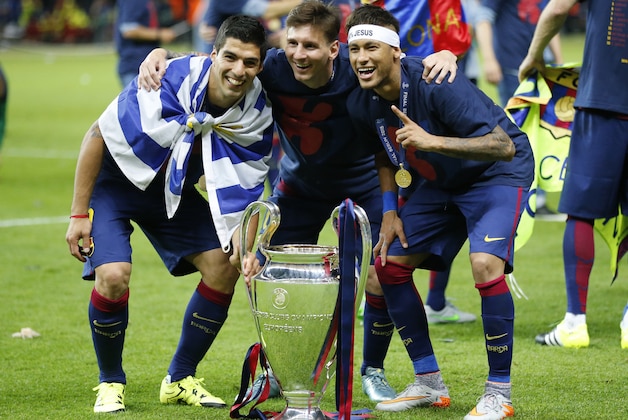 Barcelona's Lionel Messi, centre, Neymar and Luis Suarez, left, celebrate with the trophy after after the Champions League final soccer match between Juventus Turin and FC Barcelona at the Olympic stadium in Berlin Saturday, June 6, 2015. Barcelona won the match 3-1.  (AP Photo/Frank Augstein)