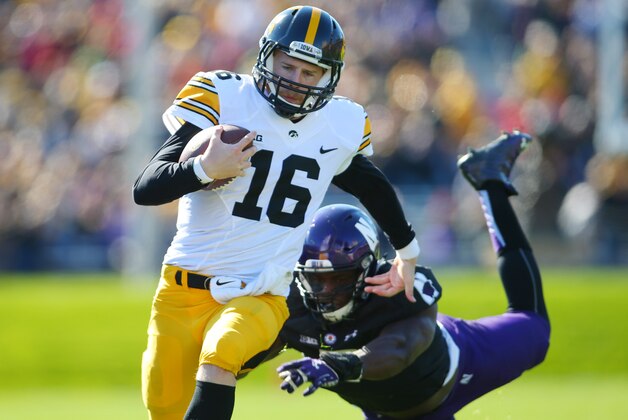 Oct 17, 2015; Evanston, IL, USA; Iowa Hawkeyes quarterback C.J. Beathard (16) avoids the tackle of Northwestern Wildcats safety Traveon Henry (2) during the first half at Ryan Field. Mandatory Credit: Caylor Arnold-USA TODAY Sports