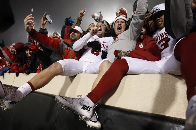 Oklahoma quarterback Baker Mayfield, center, celebrates with fans following an NCAA college football game against Oklahoma State in Stillwater, Okla., Saturday, Nov. 28, 2015. Oklahoma won 58-23. (AP Photo/Sue Ogrocki)