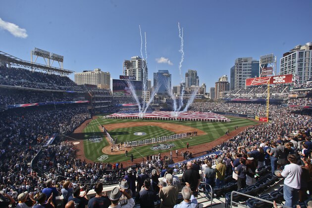 Players line the base lines at Petco Park as a large flag is displayed during the San Diego Padres' home-opener baseball game against the San Francisco Giants on Thursday, April 9, 2015, in San Diego. (AP Photo/Lenny Ignelzi)