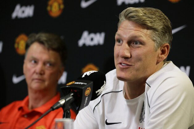 Manchester United manager Louis van Gaal, left, looks on as new signing Bastian Schweinsteiger speaks during a press conference, Wednesday, July 15, 2015, in Bellevue, Wash. Manchester United is in Seattle for an international friendly soccer match against Mexico's Club America to be played on Friday. (AP Photo/Ted S. Warren)