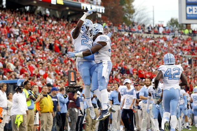 North Carolina's Cayson Collins (23) and Andre Smith (56) celebrate Smith's interception against North Carolina State during the first half an NCAA college football game in Raleigh, N.C., Saturday, Nov. 28, 2015. North Carolina won 45-34. (AP Photo/Gerry Broome)