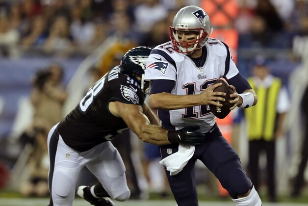 Philadelphia Eagles outside linebacker Connor Barwin, left, tries to tackle New England Patriots quarterback Tom Brady in the first quarter of an NFL football game Friday, Aug. 15, 2014, in Foxborough, Mass. (AP Photo/Charles Krupa)