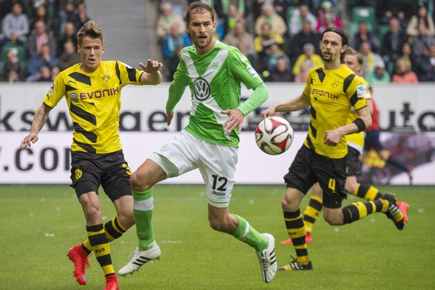 Wolfsburg's forward Bas Dost of the Netherlands (C ) and Dortmund's defender Erik Durm (L) vie for the ball during the German first division Bundesliga football match Vfl Wolfsburg vs Borussia Dortmund in Wolfsburg, central Germany, on May 16, 2015.  AFP PHOTO / ODD ANDERSEN

RESTRICTIONS - DFL RULES TO LIMIT THE ONLINE USAGE DURING MATCH TIME TO 15 PICTURES PER MATCH. IMAGE SEQUENCES TO SIMULATE VIDEO IS NOT ALLOWED AT ANY TIME. FOR FURTHER QUERIES PLEASE CONTACT DFL DIRECTLY AT + 49 69 650050.        (Photo credit should read ODD ANDERSEN/AFP/Getty Images)