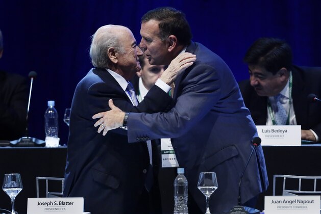 FILE - In this March 4, 2015 file photo FIFA President Sepp Blatter, left, congratulates Juan Angel Napout after the Paraguayan was confirmed as president of CONMEBOL during a general congress of the South American football confederation, in Asuncion, Paraguay. On Thursday, Dec. 3, 2015 Switzerland's justice ministry has identified FIFA vice presidents Juan Angel Napout and Alfredo Hawit as the two officials arrested today on suspicion of bribery.  (AP Photo/Jorge Saenz)