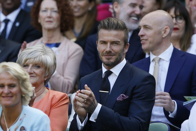 Former soccer player David Beckham, centre,  and his mother Sandra, left, applaud during the women's singles semifinal match between Garbine Muguruza of Spain and Agnieszka Radwanska of Poland, at the All England Lawn Tennis Championships in Wimbledon, London, Thursday July 9, 2015. (AP Photo/Kirsty Wigglesworth, Pool)