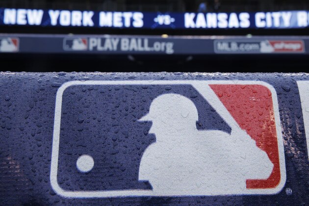 Rain drops cover a baseball logo before Game 1 of the Major League Baseball World Series between the New York Mets and Kansas City Royals, Tuesday, Oct. 27, 2015, in Kansas City, Mo. (AP Photo/Matt Slocum)