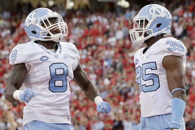 North Carolina's T.J. Logan (8) and Damien Washington (35) celebrate Logan's touchdown against North Carolina State during the first half an NCAA college football game in Raleigh, N.C., Saturday, Nov. 28, 2015. North Carolina won 45-34. (AP Photo/Gerry Broome)