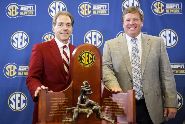Alabama head coach Nick Saban, left, and Florida head coach Jim McElwain pose with the trophy during a press conference held ahead of Saturday's Southeastern Conference championship NCAA college football game, Friday, Dec. 4, 2015, in Atlanta. (AP Photo/David Goldman)