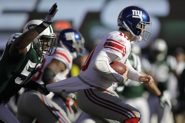 New York Giants quarterback Eli Manning, right, is sacked by New York Jets' David Harris, left, during the first quarter of an NFL football game Saturday, Dec. 24, 2011, in East Rutherford, N.J. (AP Photo/Julio Cortez)
