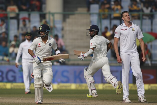 South African bowler Morne Morkel, right watches as Indian batsmen Virat Kohli, left and Ajinkya Rahane, second right run between the wickets on the third day of the fourth test cricket match between India and South Africa in New Delhi, India, Saturday, Dec. 5, 2015. (AP Photo /Tsering Topgyal)