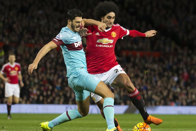 Manchester United's Marouane Fellaini, centre, fights for the ball against West Ham United's James Tomkins during the English Premier League soccer match between Manchester United and West Ham United at Old Trafford Stadium, Manchester, England, Saturday, Dec. 5, 2015. (AP Photo/Jon Super)