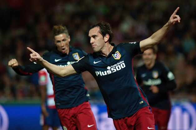 Atletico Madrid's Uruguayan defender Diego Godin (R) celebrates a goal during the Spanish league football match Granada FC VS Club Atletico de Madrid at Nuevo Los Carmenes stadium in Granada on December 5, 2015.   AFP PHOTO / JORGE GUERRERO / AFP / Jorge Guerrero        (Photo credit should read JORGE GUERRERO/AFP/Getty Images)