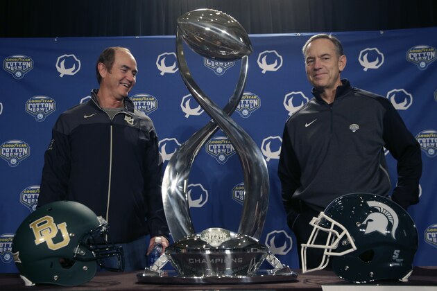 Baylor head football coach Art Briles, left, speaks to Michigan State head football coach Mark Dantonio  while they pose for photos with the Cotton Bowl champion's trophy Wednesday, Dec. 31, 2014, in Dallas. (AP Photo/LM Otero)