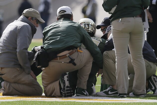 Baylor trainers check on quarterback Chris Johnson (13) after he was injured during the first half of an NCAA college football game against Texas Saturday, Dec. 5, 2015, in Waco, Texas. (AP Photo/LM Otero)