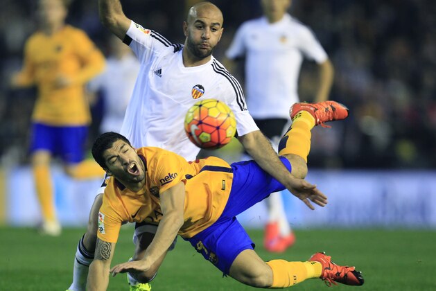 Barcelona's Luis Suarez duels for the ball with Valencia's Aymen Abdennour during a Spanish La Liga soccer match at the Mestalla stadium in Valencia, Spain, Saturday, Dec. 5, 2015. (AP Photo/Alberto Saiz)