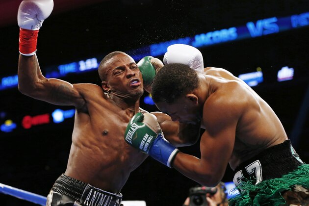 Peter Quillin, left, is hit in the head with a right by Daniel Jacobs that knocked him out during the first round in a WBA middleweight championship boxing bout in New York on Saturday, Dec. 5, 2015. (AP Photo/Rich Schultz)