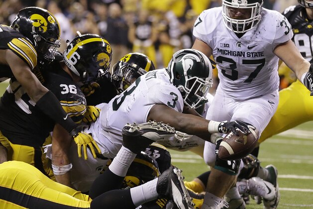 Michigan State's LJ Scott (3) runs for a 1-yard touchdown during the second half of the Big Ten Conference championship NCAA college football game against Iowa, Saturday, Dec. 5, 2015, in Indianapolis. (AP Photo/Michael Conroy)